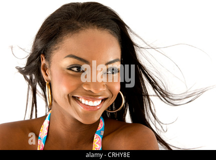 Sorridente di carnagione scura giovane donna con capelli battenti nel vento Foto Stock