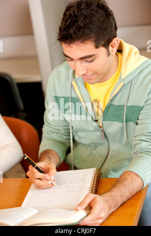 Studente universitario rendendo note su un raccoglitore ad anelli Foto Stock