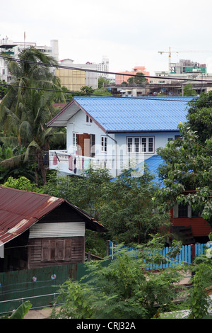 È nel sobborgo di Bangkok, vecchio, abbandonati o collassare casa in legno. Tetto blu per alcuni di essi. Ci sono alberi troppo Foto Stock