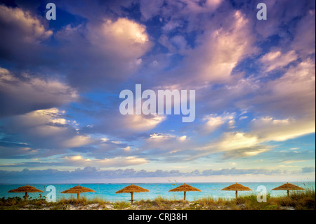 Umbellas Reed e nuvole di sunrise. Isole Turks e Caicos. Providenciales Foto Stock