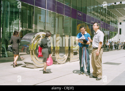 Giovane uomo woos un passerby durante una promozione Foto Stock