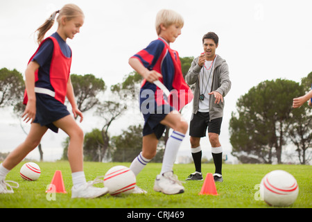 Coach training per bambini squadra di calcio Foto Stock
