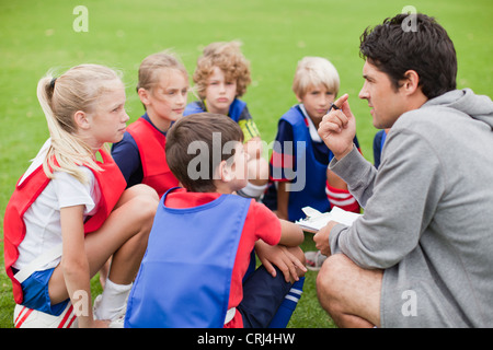 Pullman a parlare con i bambini di calcio Foto Stock