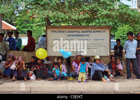 Donne, uomini e bambini in attesa di fronte all'ospedale per bambini Kantha Bopha, Cambogia Siem Reap Foto Stock