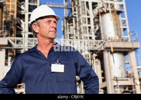 Lavoratore in piedi alla raffineria di petrolio Foto Stock