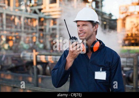 Lavoratore utilizzando walkie talkie sul sito Foto Stock