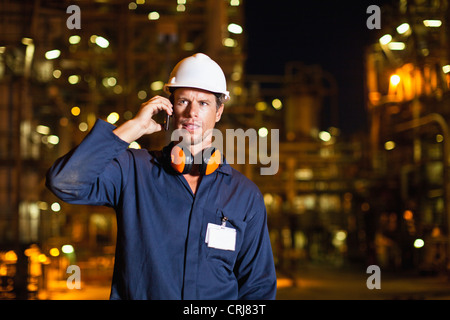 Lavoratore sul telefono cellulare alla raffineria di petrolio
