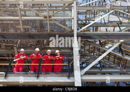 I lavoratori in piedi sulla mensola insieme Foto Stock