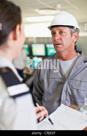 Il personale addetto alla sicurezza di parlare per lavoratore Foto Stock