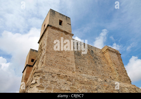 Molto vecchia torre dalla Pauls Bay su Malta con cielo blu e nuvole Foto Stock