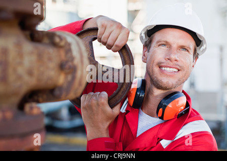 Lavoratore regolare il manometro a impianto chimico Foto Stock