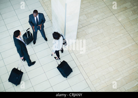 La gente di affari valigia nella lobby Foto Stock