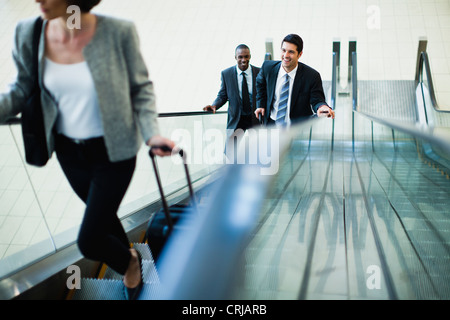 La gente di affari di escalator di equitazione Foto Stock