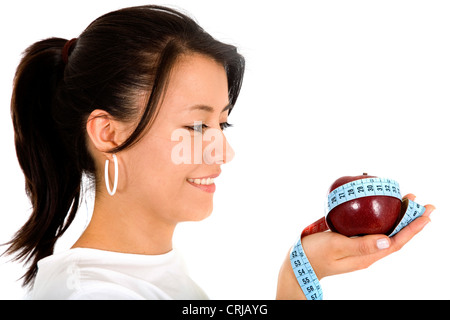 Giovane donna con red apple con un nastro di misurazione intorno Foto Stock