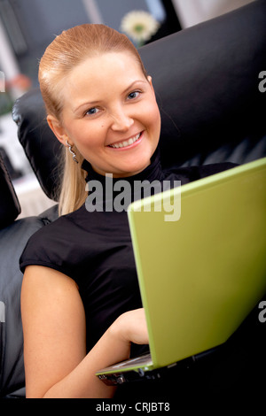 Business donna che lavorano da casa su un computer portatile Foto Stock