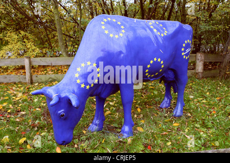 Gli animali domestici della specie bovina (Bos primigenius f. taurus), modello a grandezza di una mucca grasing nella UE-blu e con l'UE-simbolo in piedi su un prato Foto Stock