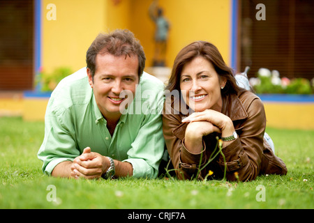 Coppia felice al di fuori della loro casa in una giornata di sole guardando molto felici e rilassati - entrambi sorridente Foto Stock