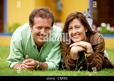 Coppia felice al di fuori della loro casa in una giornata di sole guardando molto felici e rilassati - entrambi sorridente Foto Stock