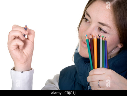 Giovane donna con una mano piena di colorati disegno pecils qualcosa su un immaginario vetro nella parte anteriore della sua Foto Stock