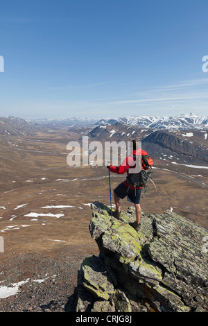 Un escursionista guarda attraverso la tomaia Nigu River Valley nei cancelli dell'Artico Parco nazionale e preservare, Brooks Range, Alaska Foto Stock