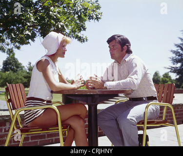 Giovane seduti ad un tavolo all'aperto Foto Stock