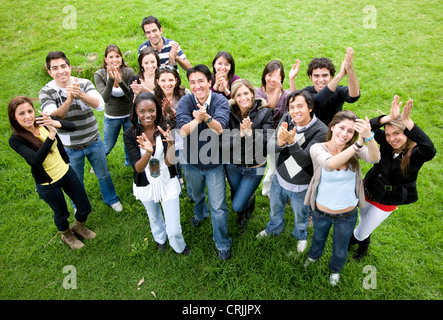 Amici casual sorridente e battendo le mani verso l'alto nel parco Foto Stock