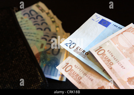 10 e 20 le banconote in euro con, in una lady borsa nera, una ventola di 20 banconote in background Foto Stock