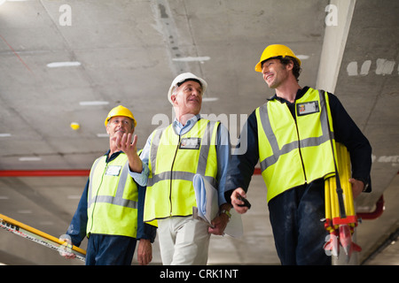 Lavoratori a piedi a sito in costruzione Foto Stock