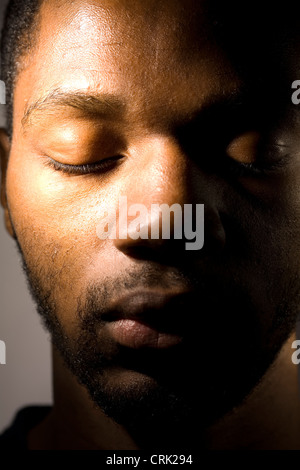 Close up del volto di un giovane uomo con gli occhi chiusi. Foto Stock