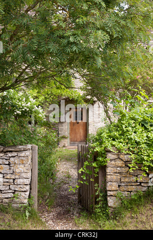 Cottage in pietra di Cotswold con cancello aperto in muro di pietra, Kelmscott, Oxfordshire occidentale, Inghilterra, Regno Unito Foto Stock