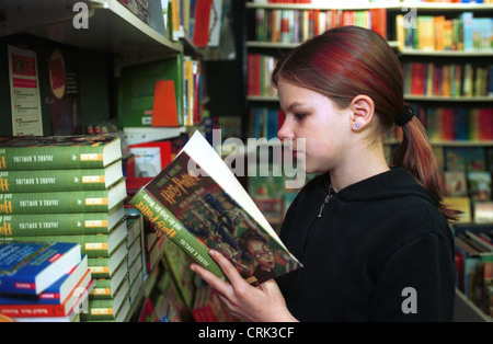 Ragazza di lettura in una libreria Foto Stock