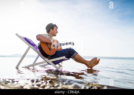 Uomo relax nel prato sedia in creek Foto Stock