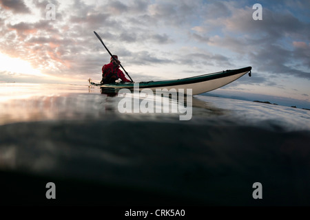 L'uomo kayak sul lago ancora Foto Stock