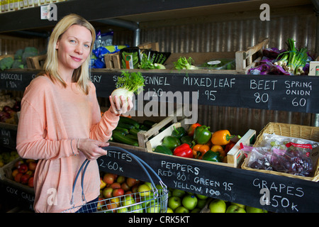 Donna acquisto di produrre in negozio Foto Stock