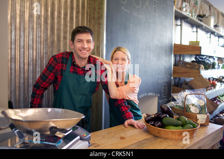 Negozio di generi alimentari a sorridere insieme in negozio Foto Stock