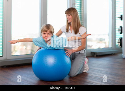 Il trainer lavora con ragazzo in palestra Foto Stock