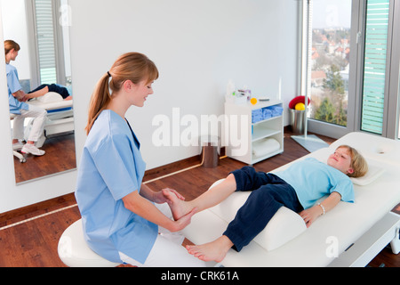 Medico di esaminare i ragazzi in piedi in ufficio Foto Stock