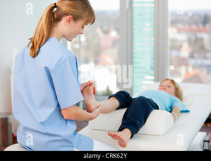 Medico di esaminare i ragazzi in piedi in ufficio Foto Stock