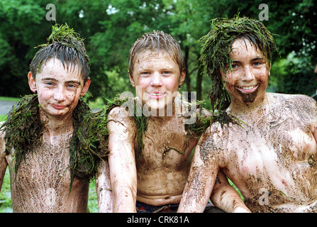 Tre ragazzi coperto di fango e di erba Foto Stock