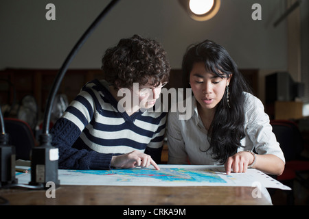 Gli studenti mappa di lettura in classe Foto Stock