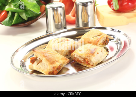 Pasta sfoglia con ripieno di formaggio e peperoni su uno sfondo luminoso Foto Stock