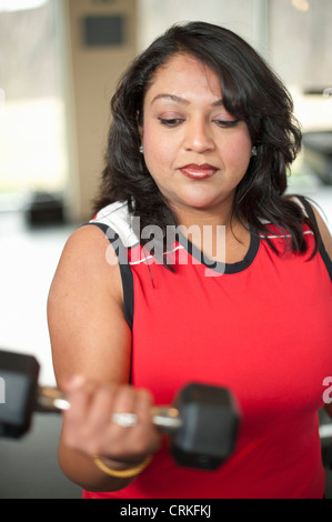 Donna sollevamento pesi nella palestra Foto Stock