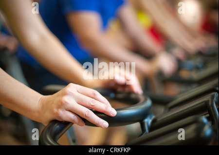 Le persone che usano le macchine di spin in palestra Foto Stock