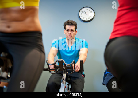 Le persone che usano le macchine di spin in palestra Foto Stock