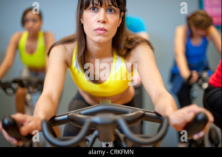 Le persone che usano le macchine di spin in palestra Foto Stock