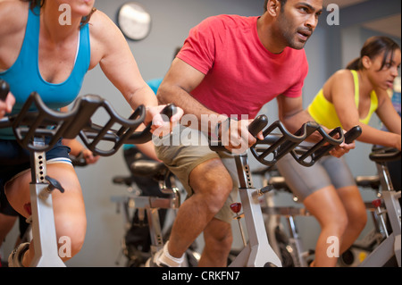 Le persone che usano le macchine di spin in palestra Foto Stock