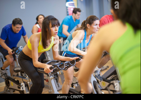 Le persone che usano le macchine di spin in palestra Foto Stock