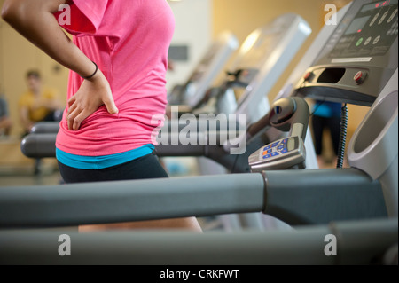 Donna che utilizza il tapis roulant in palestra Foto Stock