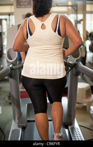 Donna che utilizza il tapis roulant in palestra Foto Stock