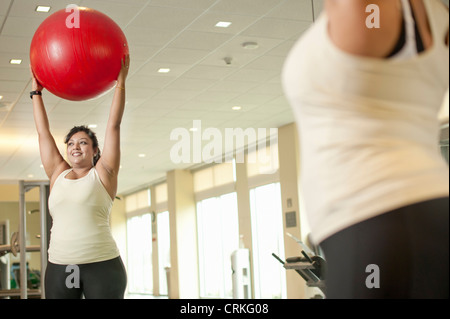 Donna con palla ginnica in palestra Foto Stock